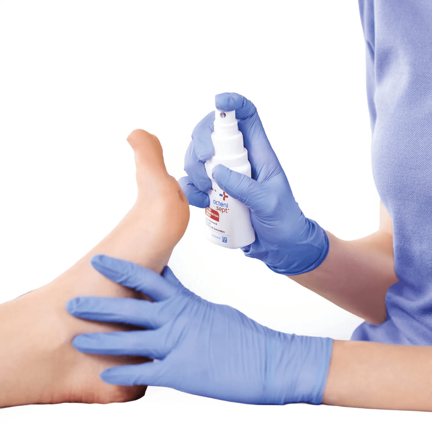 Clinician applying octenisept spray to a patient's ankle